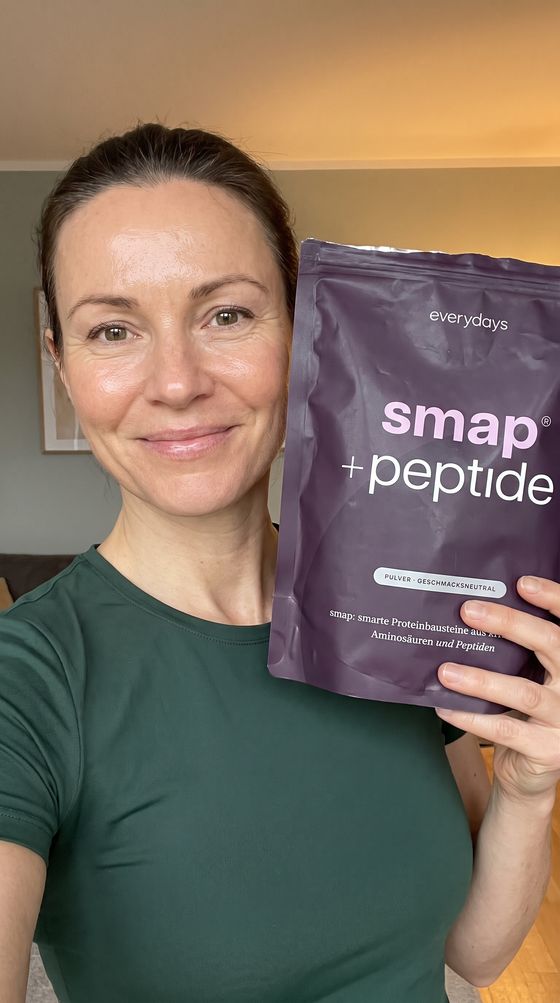 Creatorin im grünen Shirt hält smap +peptide neben ihr Gesicht